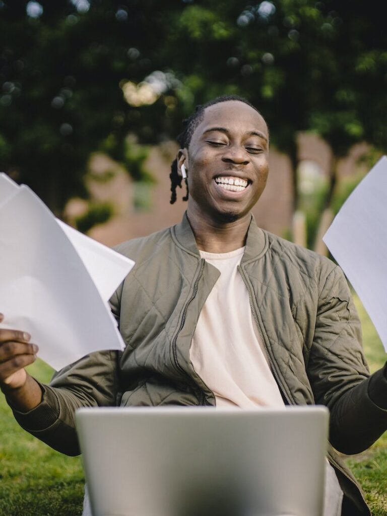 Student with documents and laptop happy about getting into university