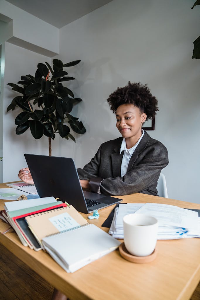 Smiling Woman Sitting Behind a Desk and Using Laptop | Why Choose Zindua School