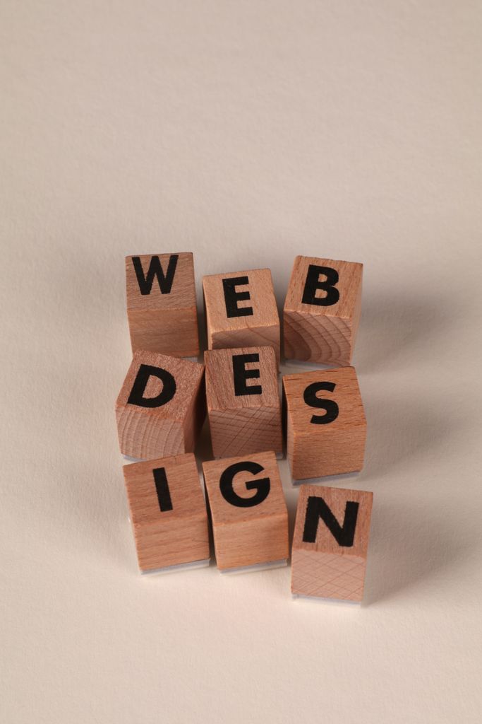 Build with AI Course 1 Wooden blocks arranged to spell 'Web Design'. In our Build with AI course, students will learn web design then how to ship it